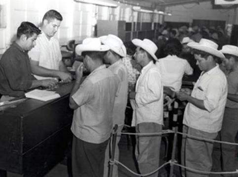 Image of  INS employees Rogelio De La Rosa (left) and Richard Ruiz (right) provided forms and instructions.