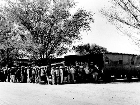 Image of Bracero poulation After Customs, Agriculture, and Immigration inspection, and obtaining Bracero Program documentation, workers boarded transportation to the farm of their new employer.  Rio Vista Reception Center, El Paso, Texas.