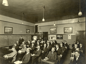 Classroom of men attending a naturalization class meeting